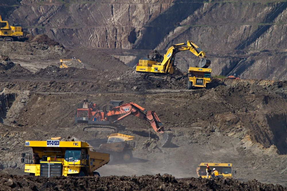 Excavators and haul trucks at an open-pit mine